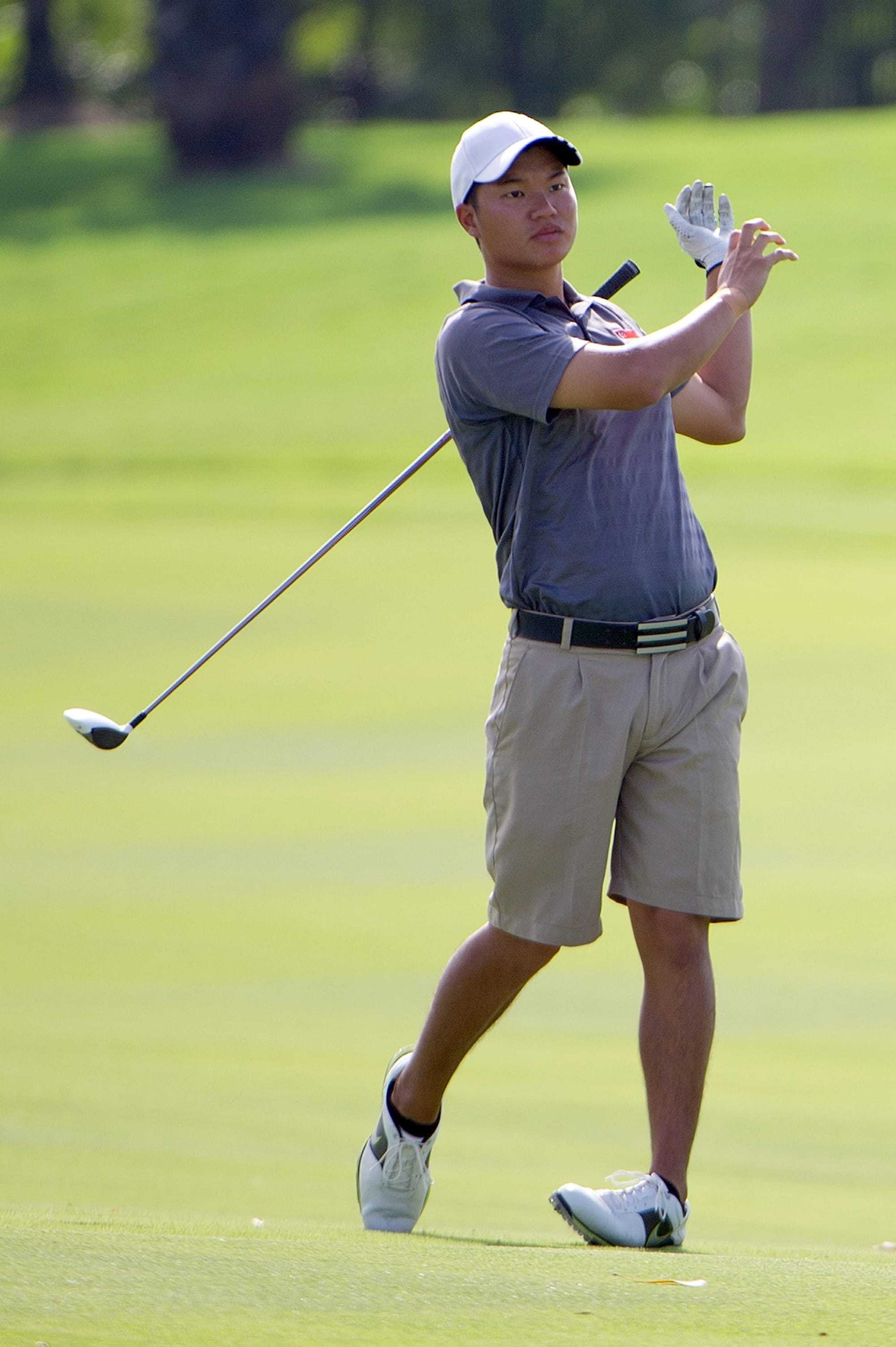 Singapore's Jonathan Woo loses his grip on the club.