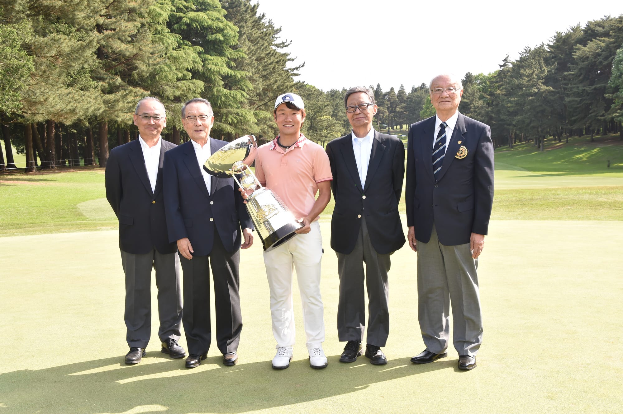 Tournament officials pose with the 2019 champion.
