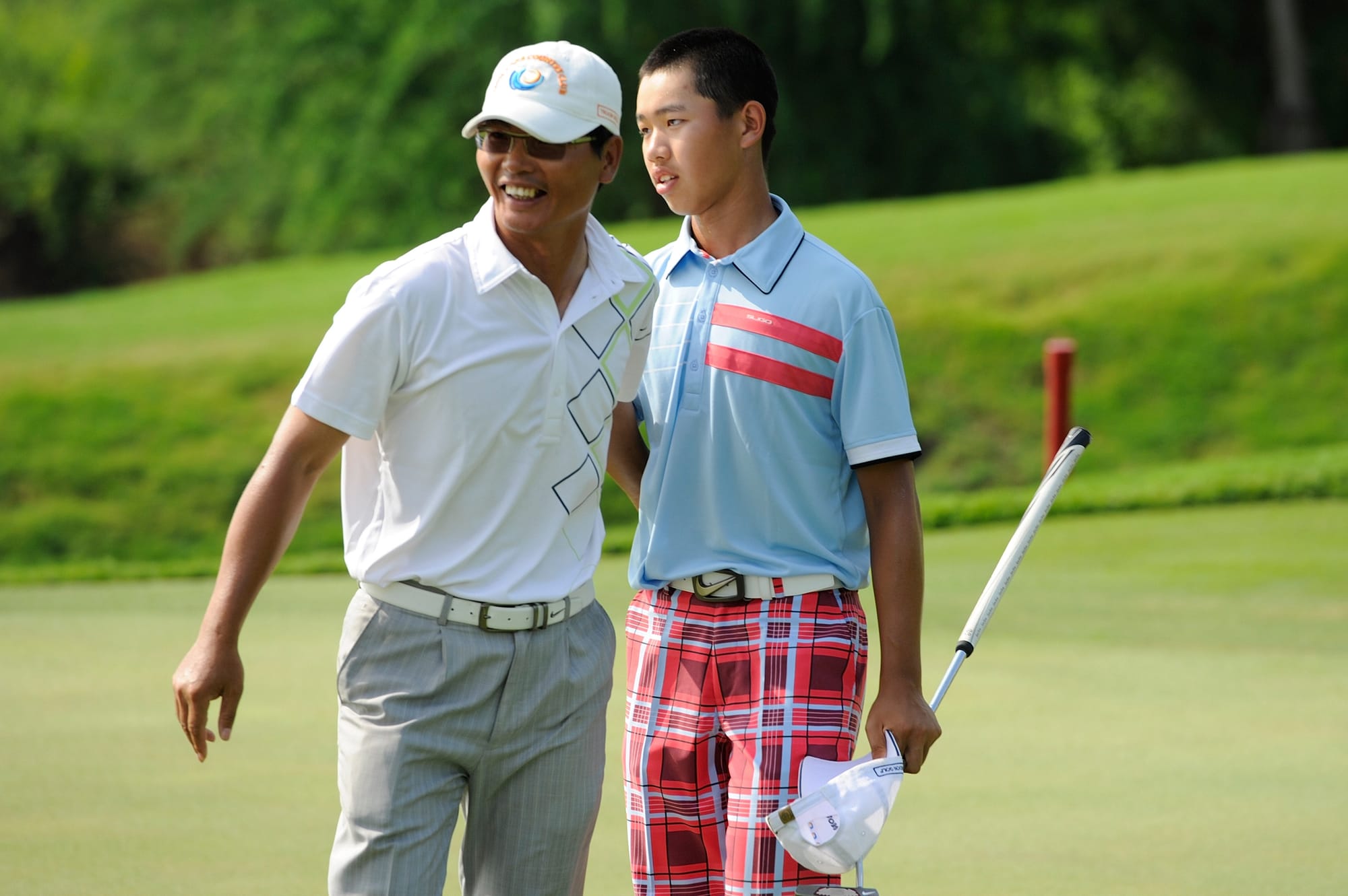 Guan Tianlang is congratulated by his father following his momentous triumph at Amata Spring Country Club.